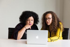 two women of colour working together at an Apple laptop